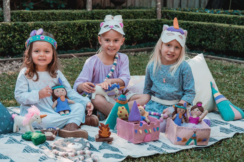 Children engaging in creative play with plush toys in a garden setting, promoting Play Based Learning Australia.