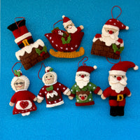 Colorful handmade felt Santa in sleigh Christmas decoration and festive characters on blue background.