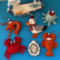 Oyster Christmas decoration and festive sea animal ornaments on a blue background for holiday decor.