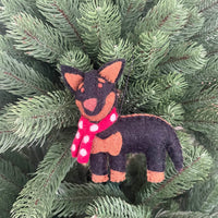 Kelpie dog Christmas decoration with a scarf hanging on a pine tree.