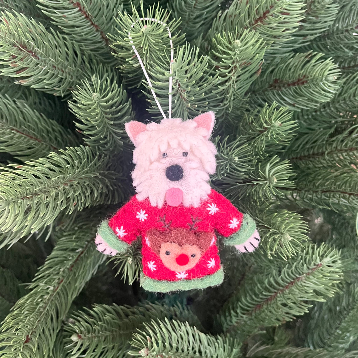 Dogs in Christmas sweater decorations featuring a cute dog ornament wearing a red holiday sweater on a Christmas tree.
