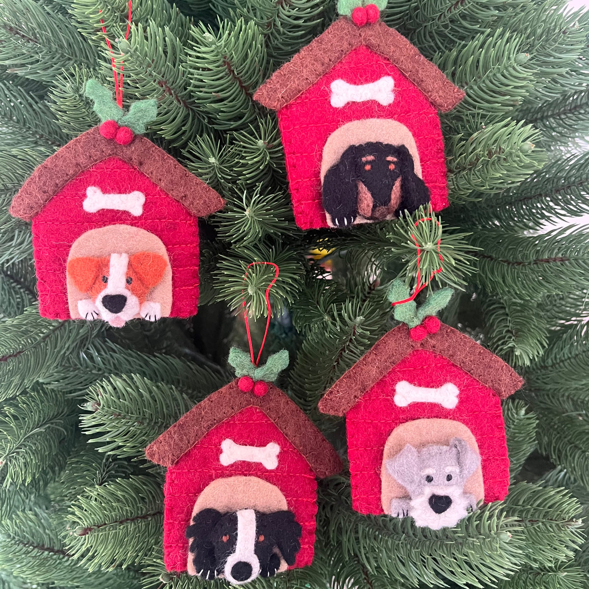 Decorative Christmas ornaments featuring various dog breeds in red kennels, perfect for festive holiday decor.
