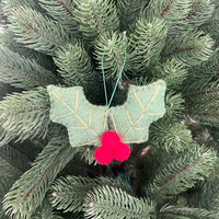 Christmas Holly leaves decoration on a Christmas tree with red berries, adding festive charm and holiday spirit.