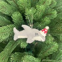 Christmas Shark Decoration hanging on green pine branches, featuring a festive red and white hat.