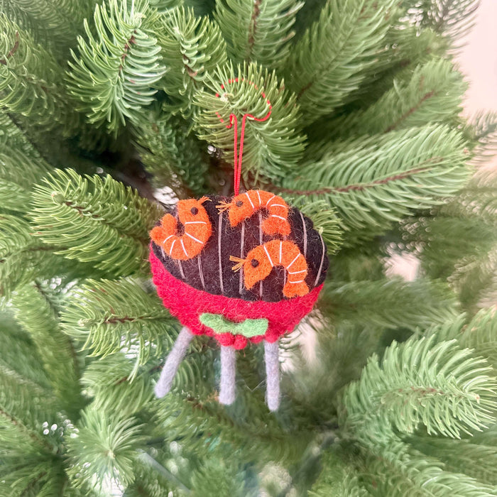 Prawn on BBQ Christmas decoration hanging on a Christmas tree, featuring felt shrimp and a vibrant barbecue design.