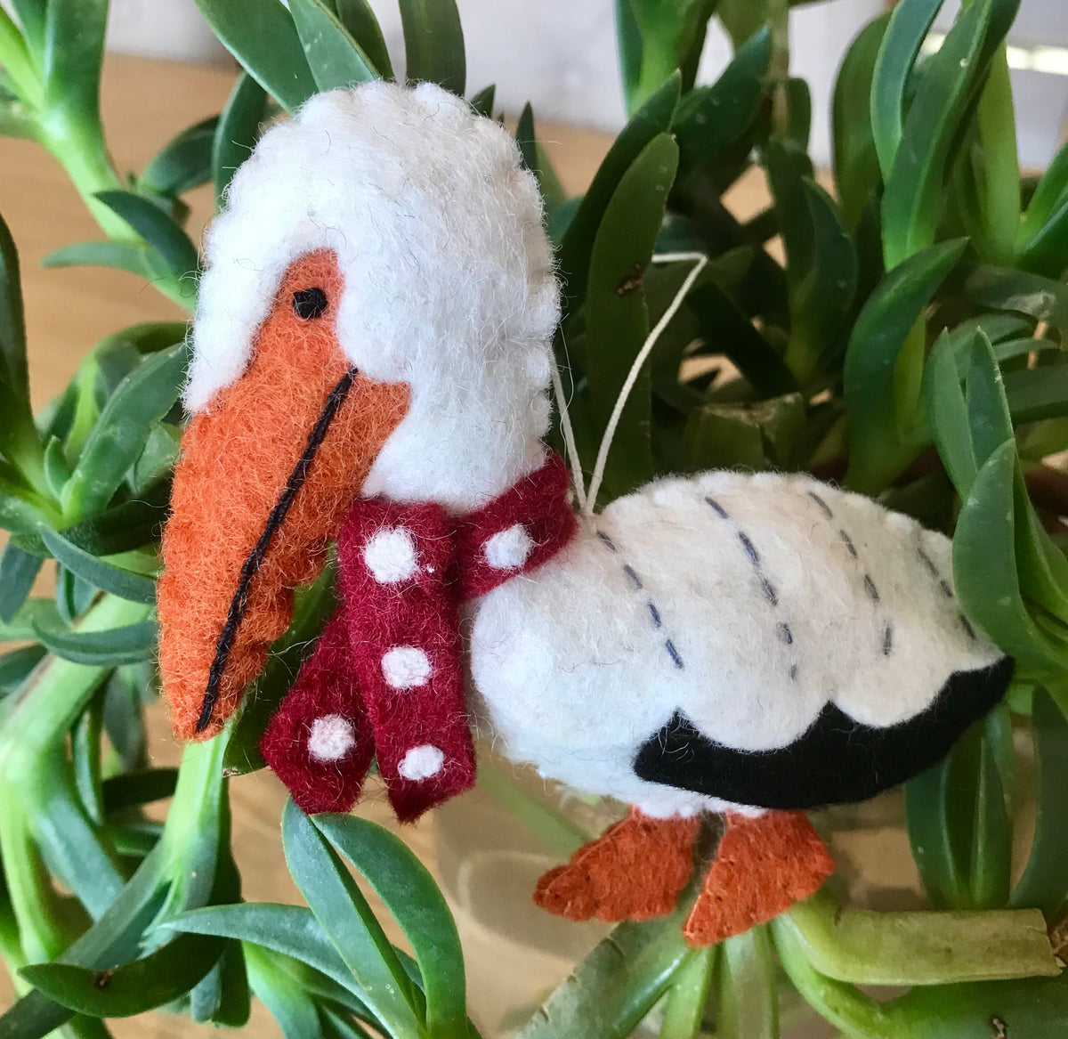 Handmade felt Christmas Pelican Decoration with a red polka dot scarf, perfect for festive coastal decor.