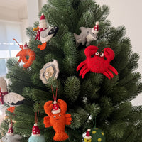 Oyster Christmas decoration and whimsical sea-themed ornaments on a holiday tree.