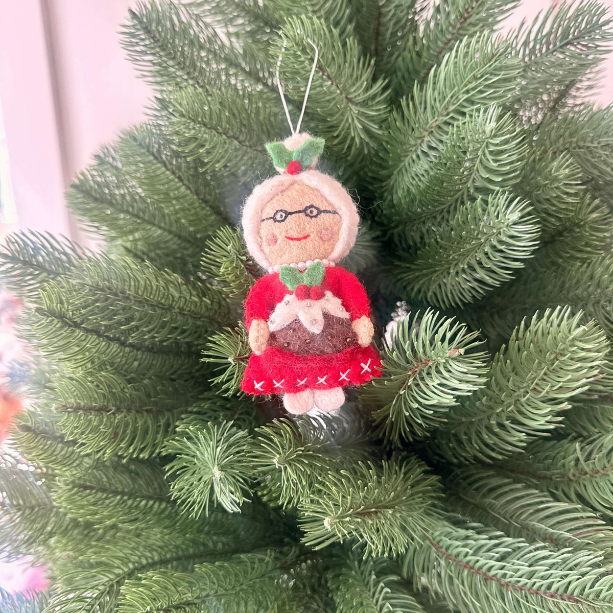 Santa and Mrs Claus with Christmas treats decorations - Mrs Claus ornament holding a Christmas pudding on a festive tree.